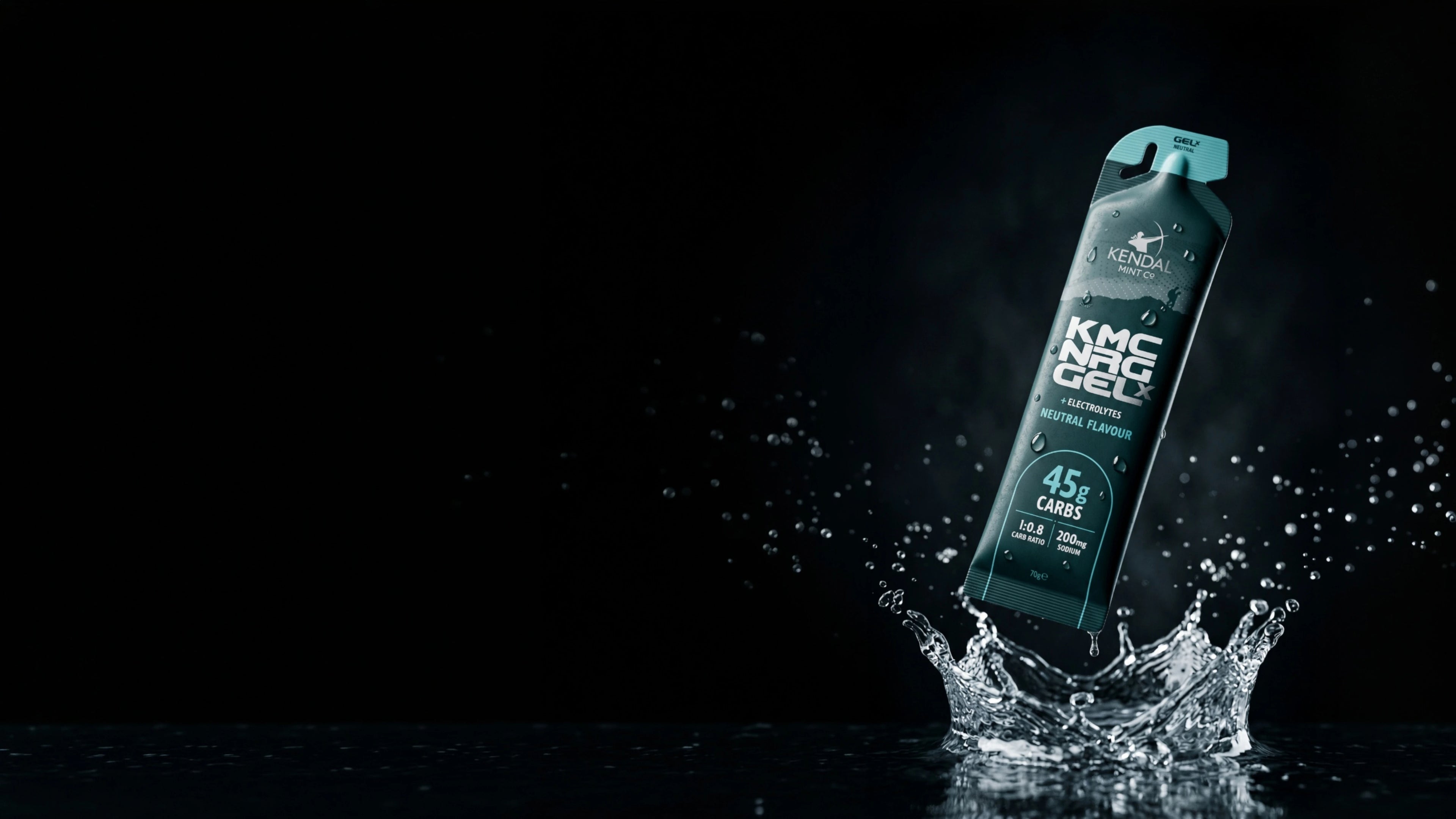 A single tube of KMC NRG GEL X neutral flavour gel pack stands upright on a splash of water against a black background.